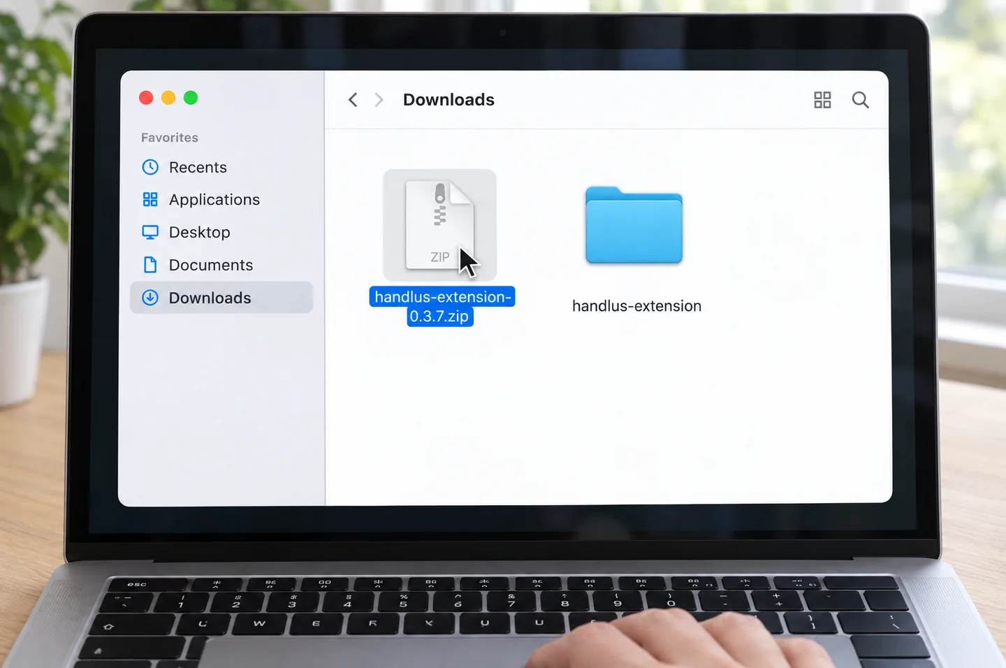 The Downloads folder in Finder on a MacBook screen. Double-clicking the handlus-extension zip puts a handlus-extension folder next to it